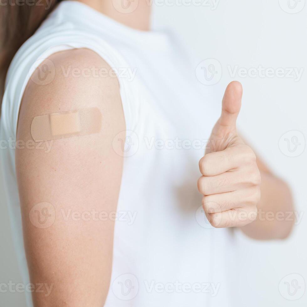 Woman with bandage after receiving vaccine. Vaccination and Immunization for Influenza, HPV, Zoster, IPD, DTP or Diphtheria, Tetanus and Pertussis, MMR, Hepatitis B, Covid and Varicella vaccine photo