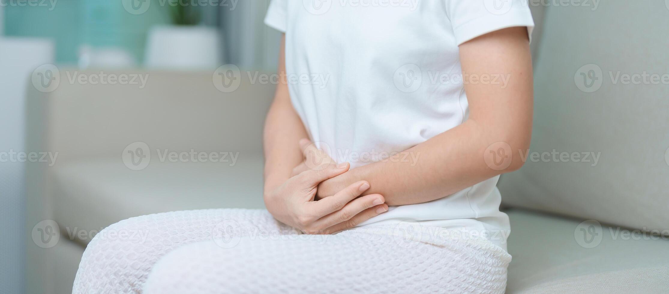 woman having abdomen ache due to Stomach pain, digestion with constipation or Diarrhea from food poisoning, female problem and Endometriosis, Hysterectomy, Stomachache and Menstrual on sofa at home photo