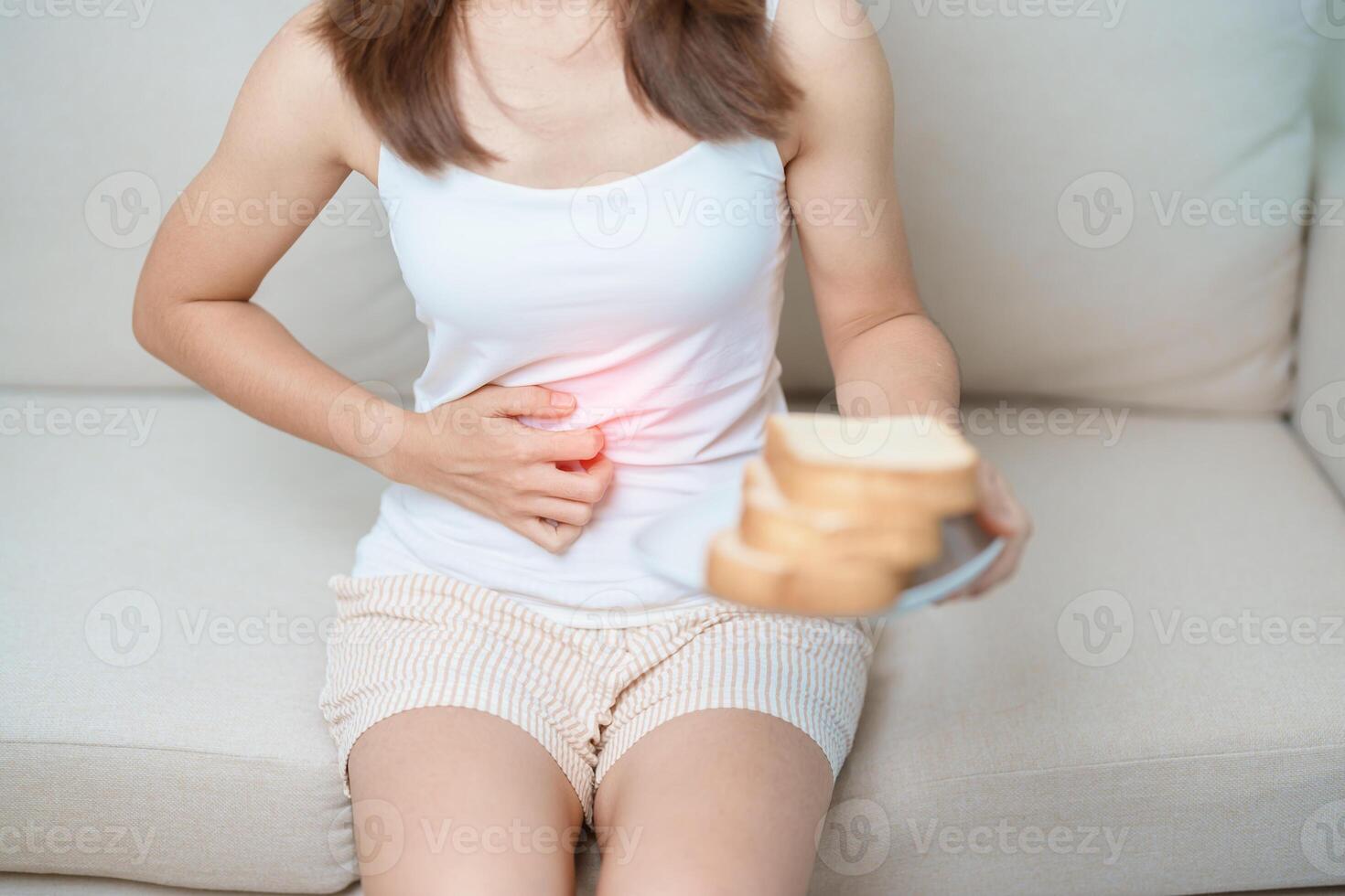 Gluten intolerance, Gluten free and celiac disease or wheat allergy concept. woman hold Bread and having abdominal pain after eat gluten. stomach ache, Nausea, Bloating, Gas, Diarrhea and Skin rash photo