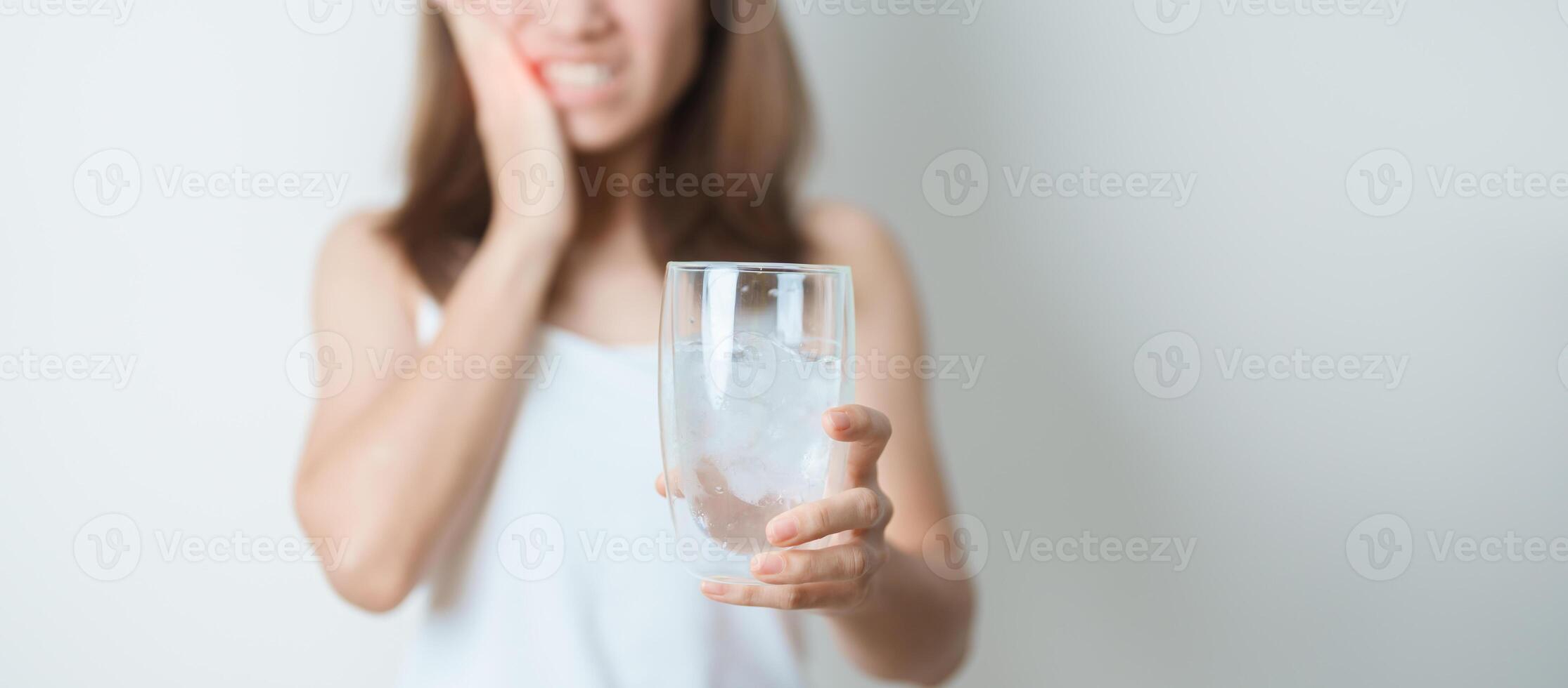 dientes sensible a frío concepto. mujer sostener hielo agua vaso y teniendo dolor de muelas y dolor después comer. diente decaer o goma enfermedad, molienda dientes y estrés, expuesto nervio raíces, grieta y retrocediendo cena foto