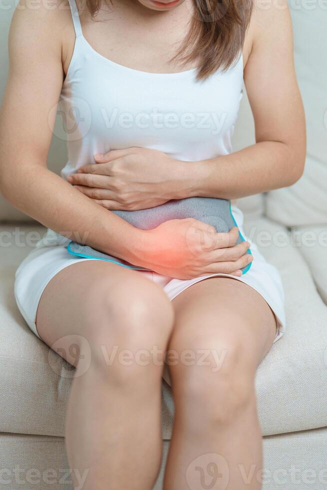 Menstruation period cycle of monthly and Stomachache concepts. woman having abdomen pain and menstrual ache with hot water bottle, illness female suffer from premenstrual ache and body Health problem photo
