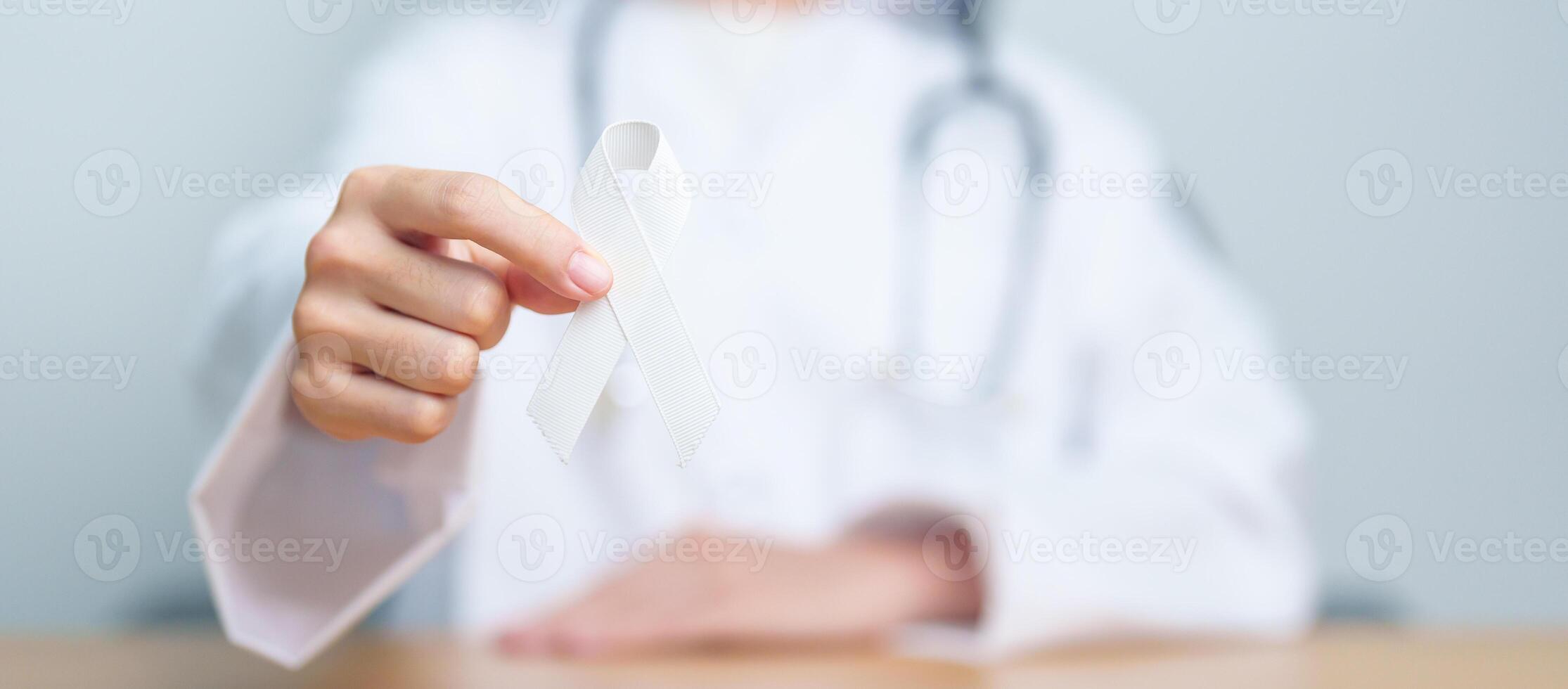 November Lung Cancer Awareness month. Doctor with White ribbon in hospital. Healthcare and World Cancer day concept photo