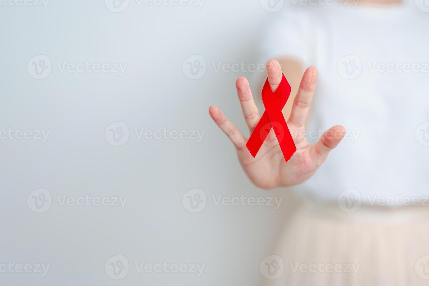 woman with Red Ribbon for December World Aids Day, acquired immune deficiency syndrome, multiple myeloma Cancer Awareness month and National Red ribbon week. Healthcare and world cancer day concept photo