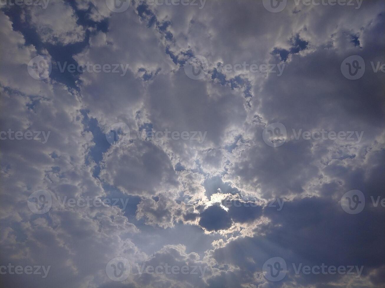 Whites clouds covering the sun in the sky. photo