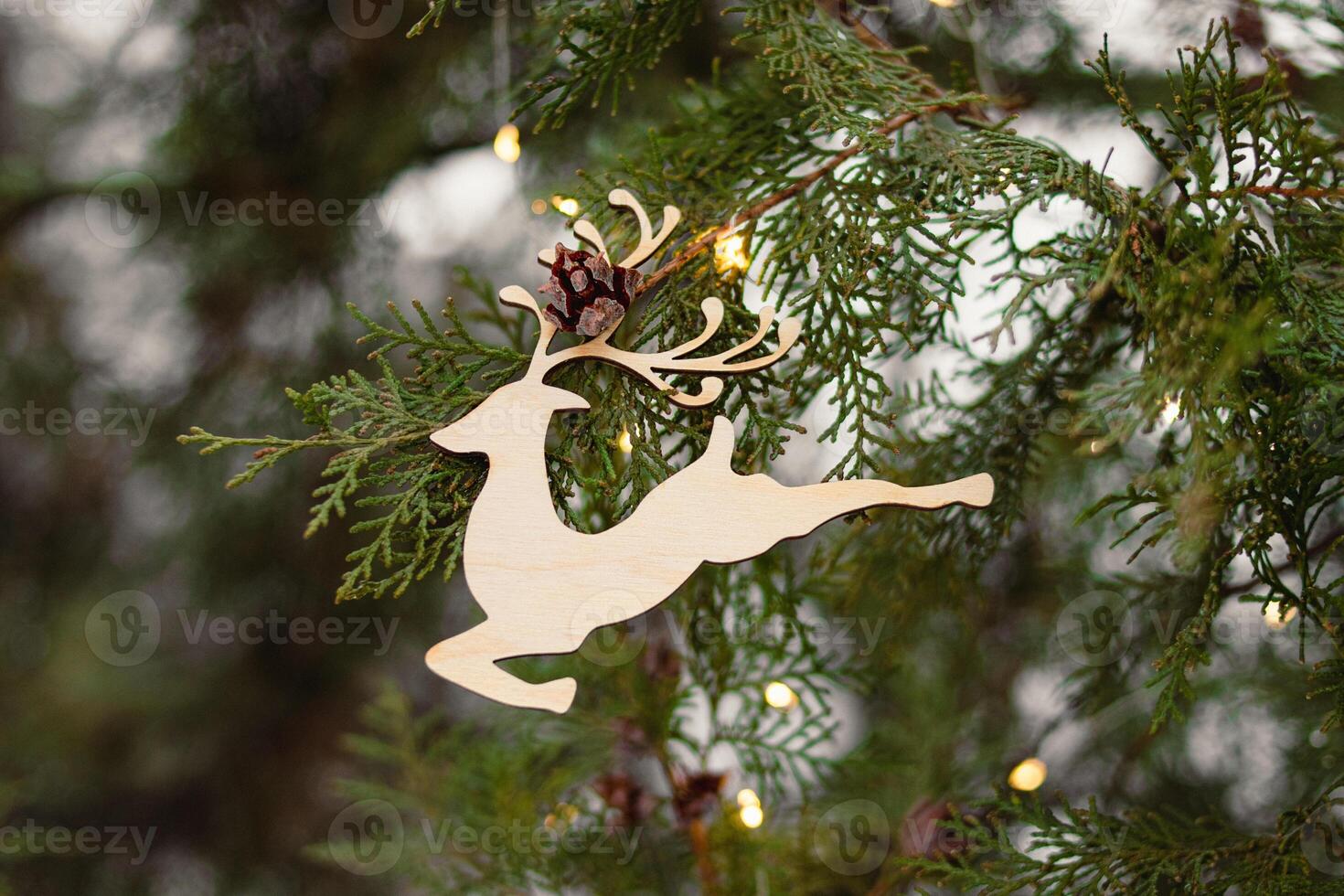 Wooden toy for the Christmas tree in the form of a deer. Merry Christmas photo