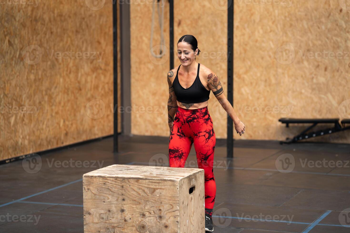 Strong woman about to jump into box in a gym photo