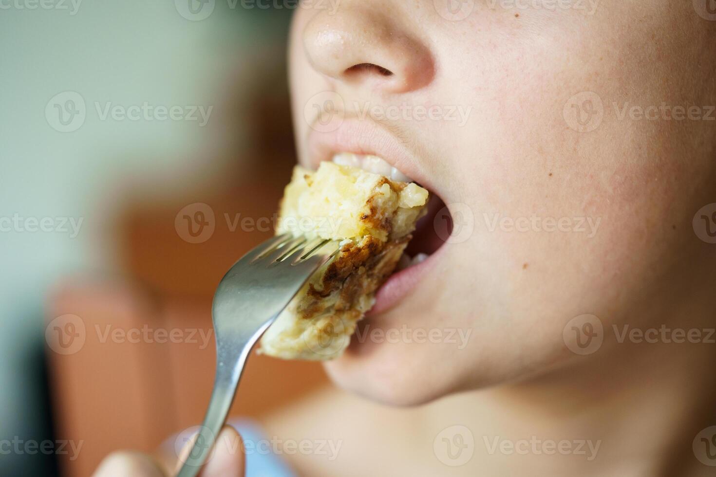 Crop anonymous girl eating fresh yummy Spanish potato omelette from fork photo