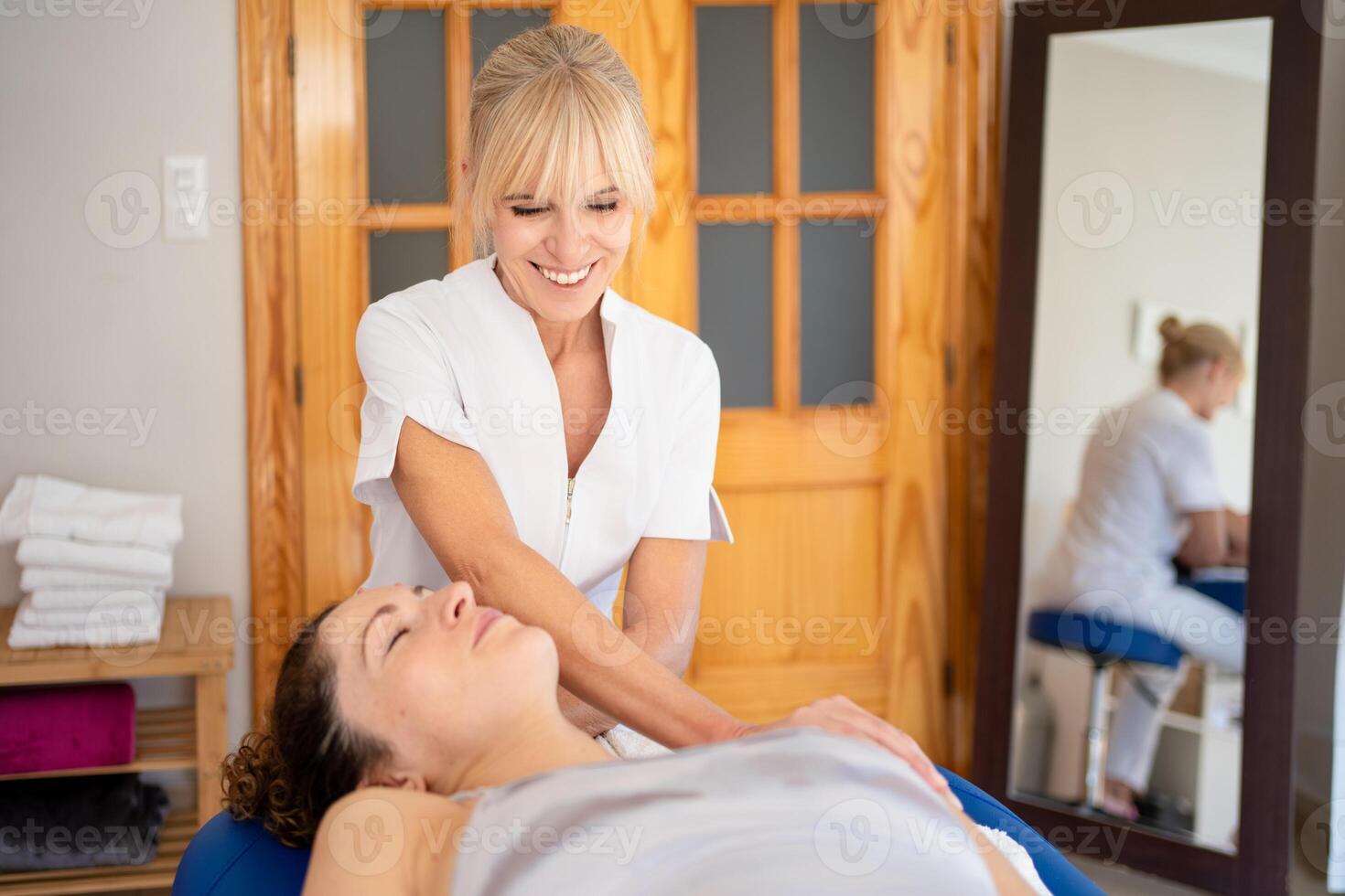 sonriente fisioterapeuta tratando paciente en hospital habitación foto