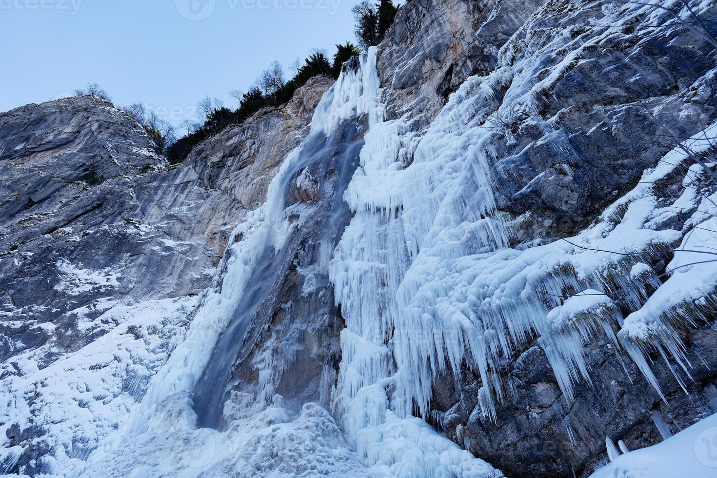 View of a partially frozen waterfall. Beautiful and magical winter holiday scenery for nature lovers. Skakavac waterfall in Sarajevo, Bosnia and Herzegovina. photo