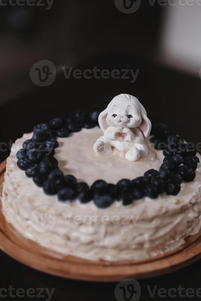 a cake with a rabbit on it and blueberries on the top. photo