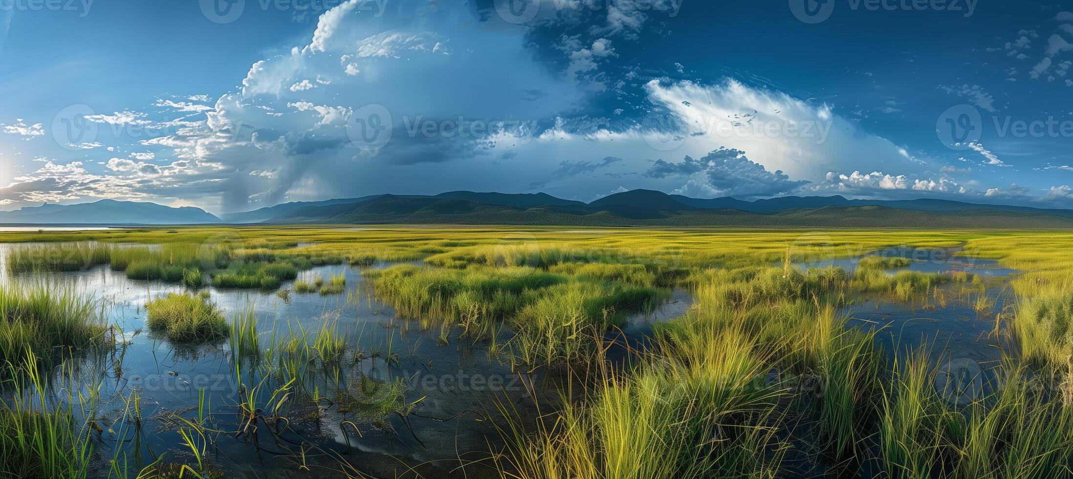Wide-angle landscape photo overlooking a mountain lake with a backdrop of mountains