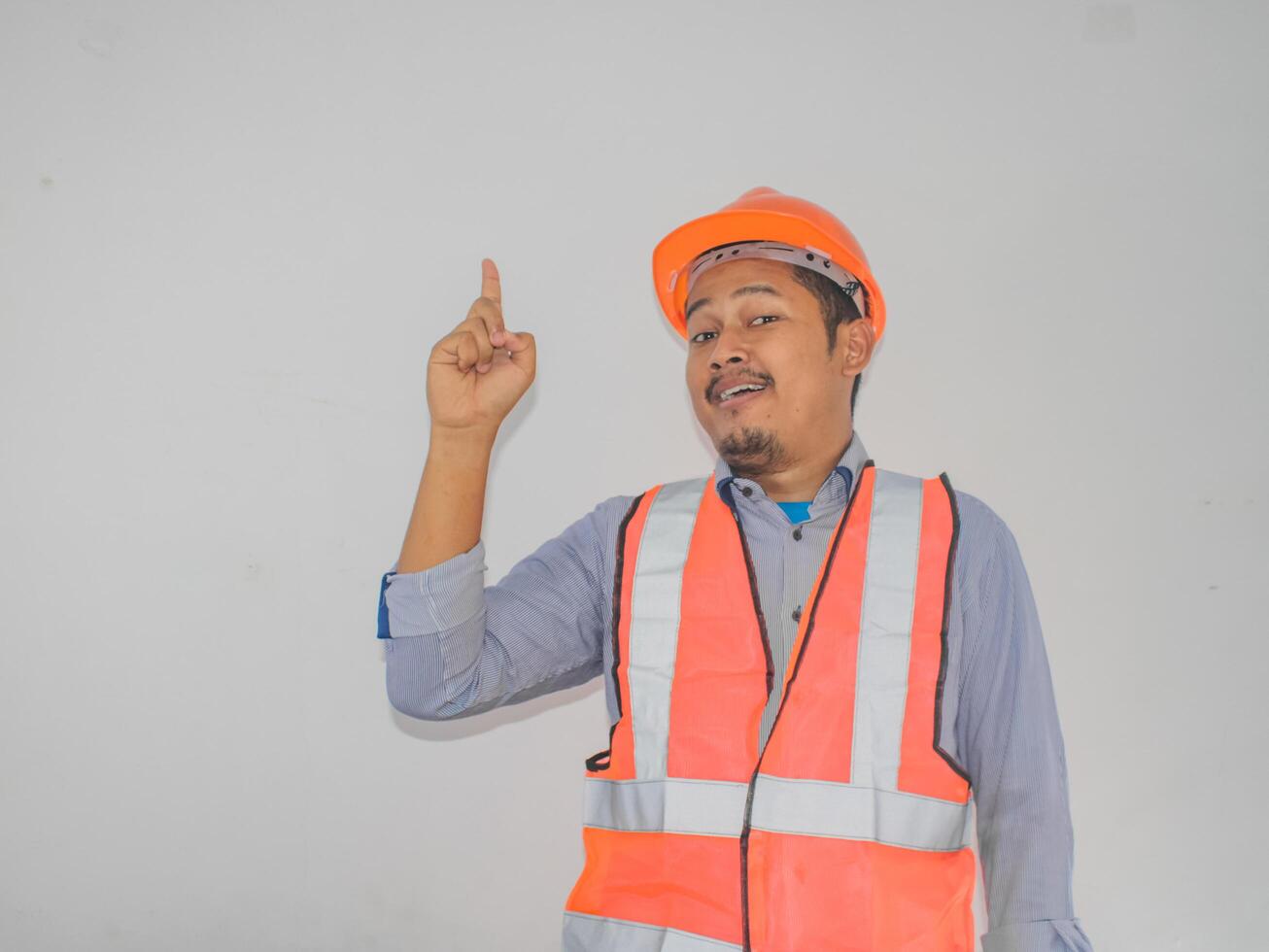 Asian workers wearing helmets are seen looking for ideas in completing work against white background photo