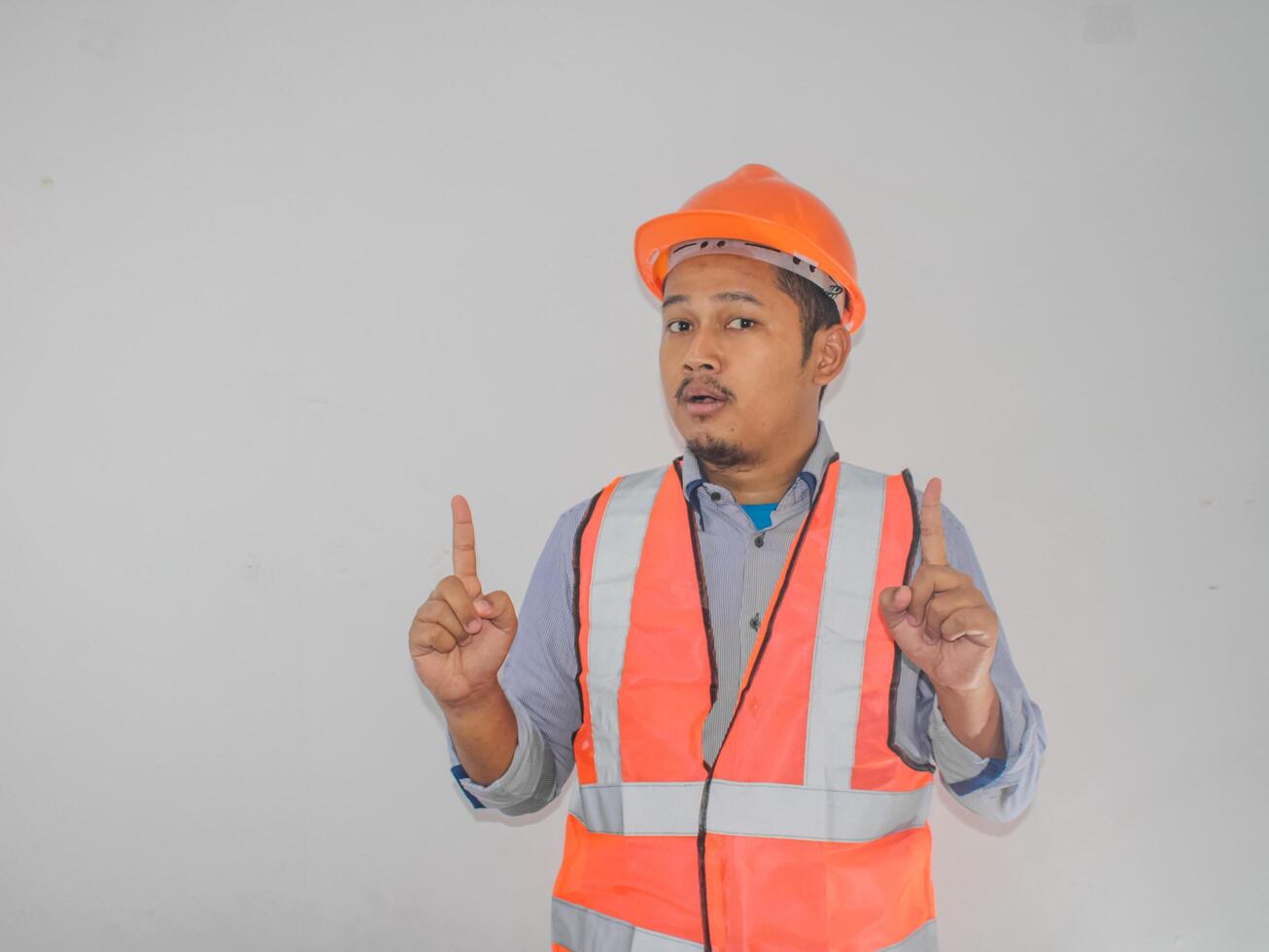 A man wearing construction socked expression with thumbs up pointing photo