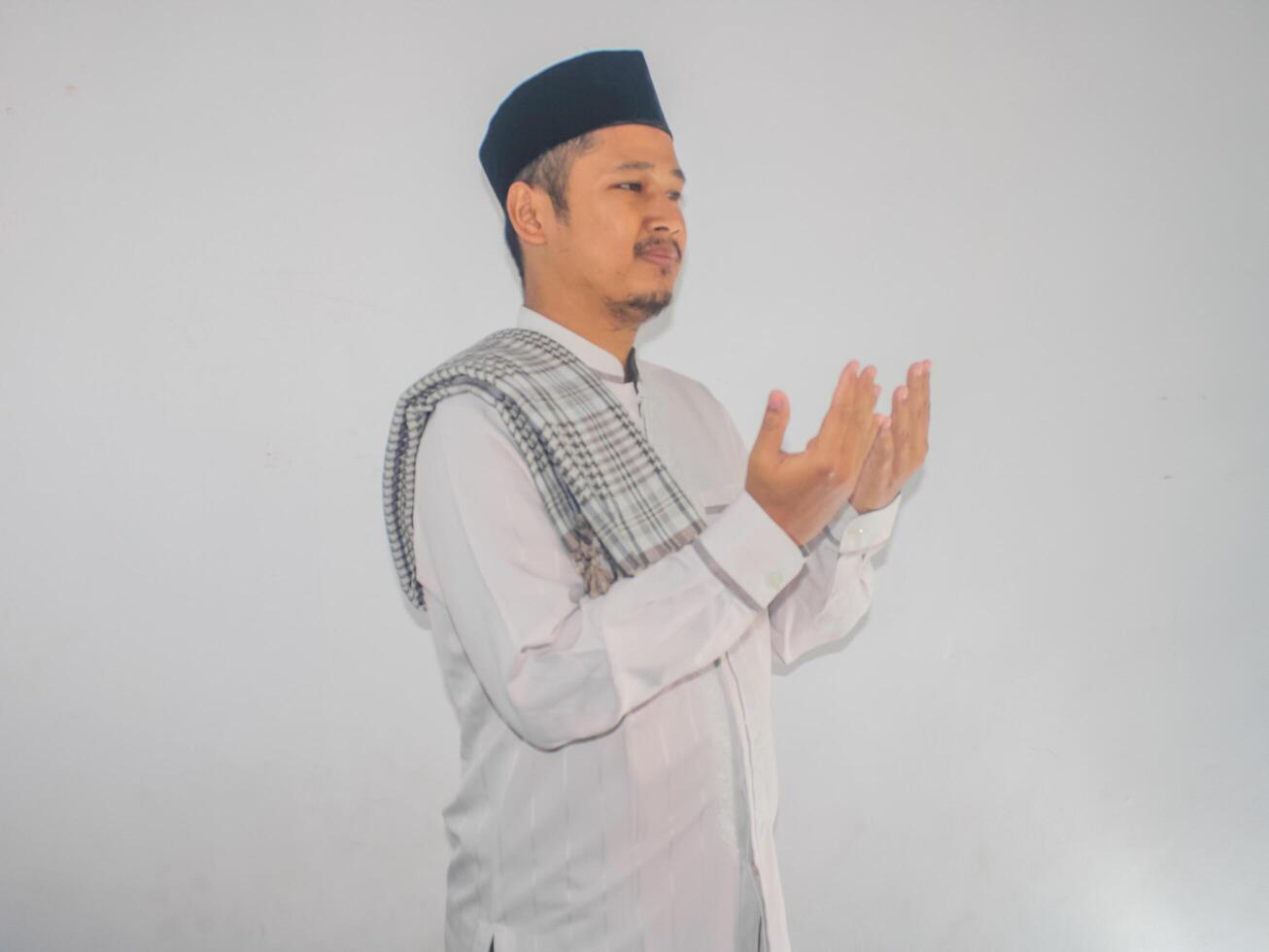 Moslem man smiling and looking above while doing praying pose photo