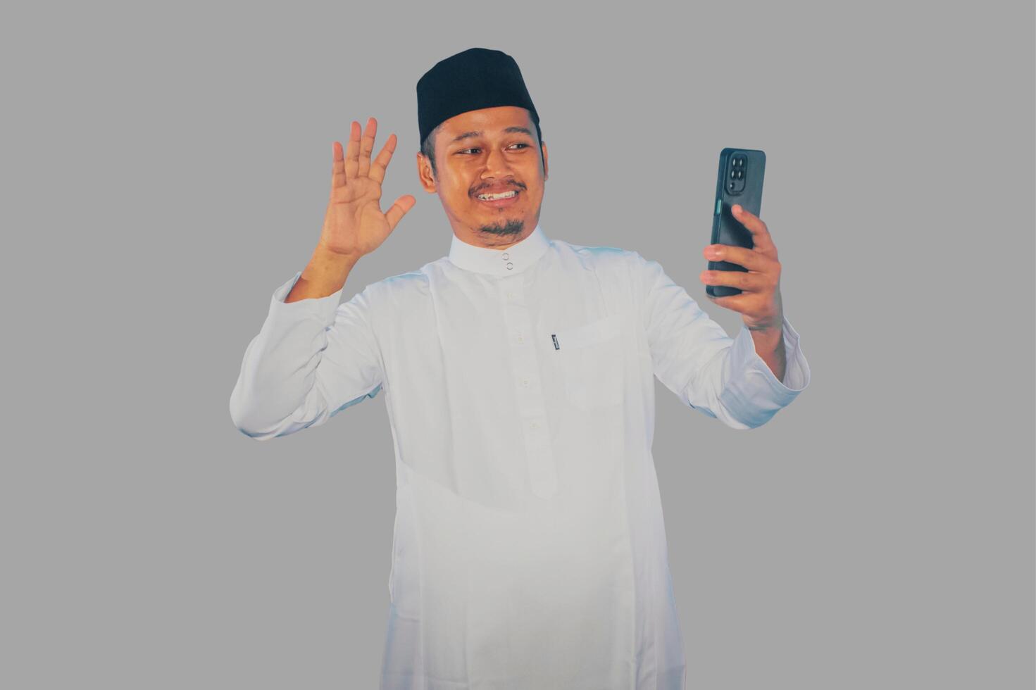 Moslem Asian man showing excited face expression during call with his family during Ramadan celebration photo