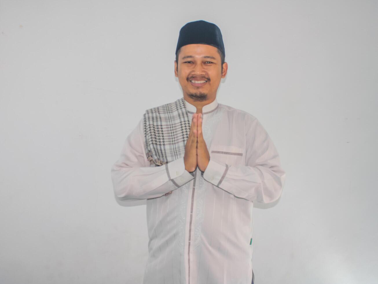 Moslem Asian man smiling to give greeting during Ramadan celebration photo