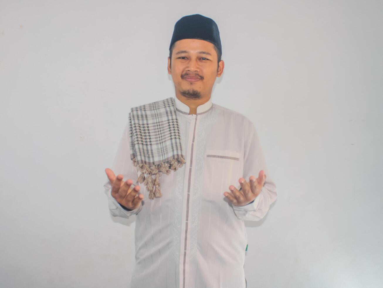 Moslem man smiling and looking above while doing praying pose photo