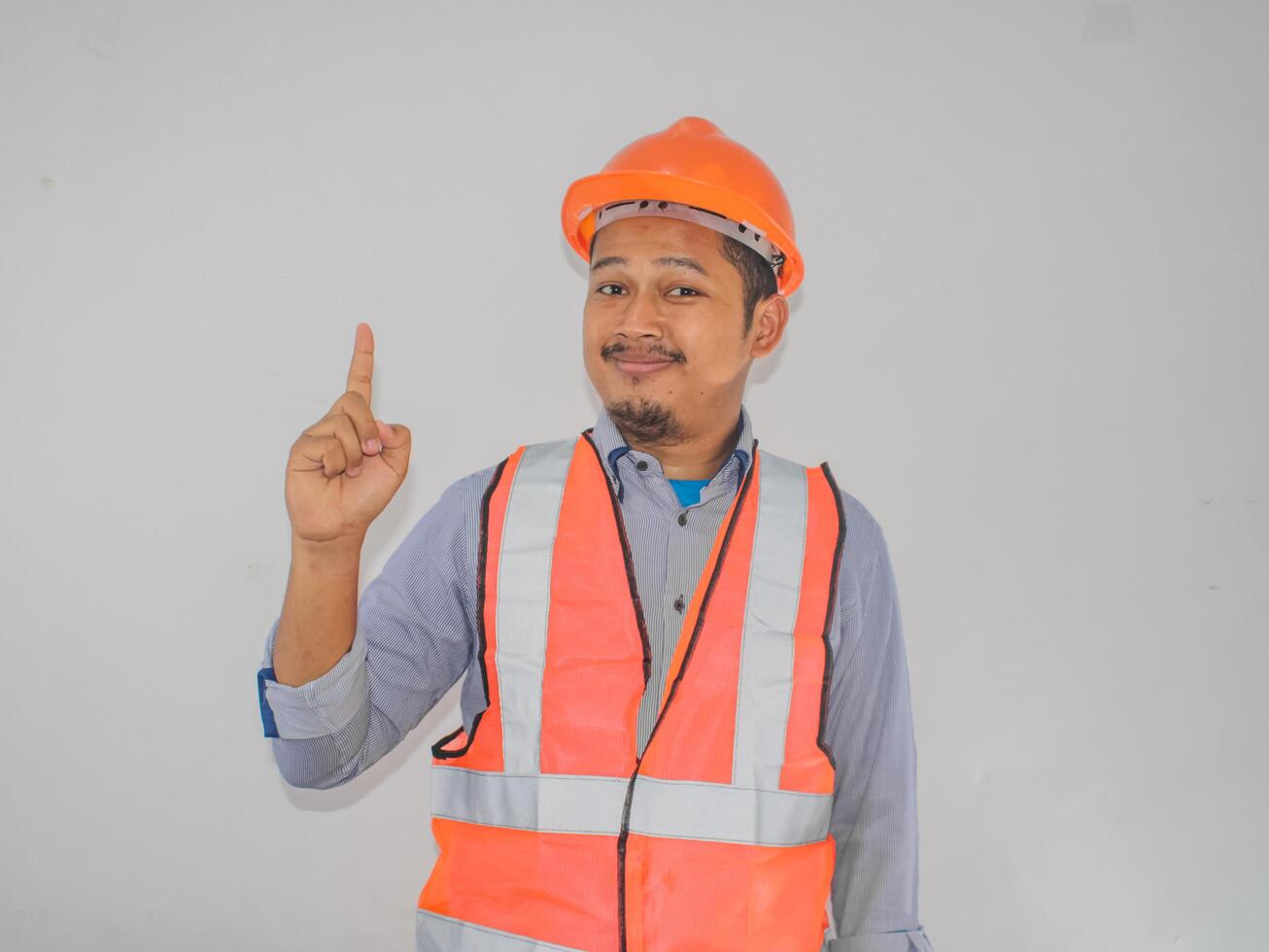 Asian workers wearing safety vest and helmets are seen looking for ideas in completing work against white background photo