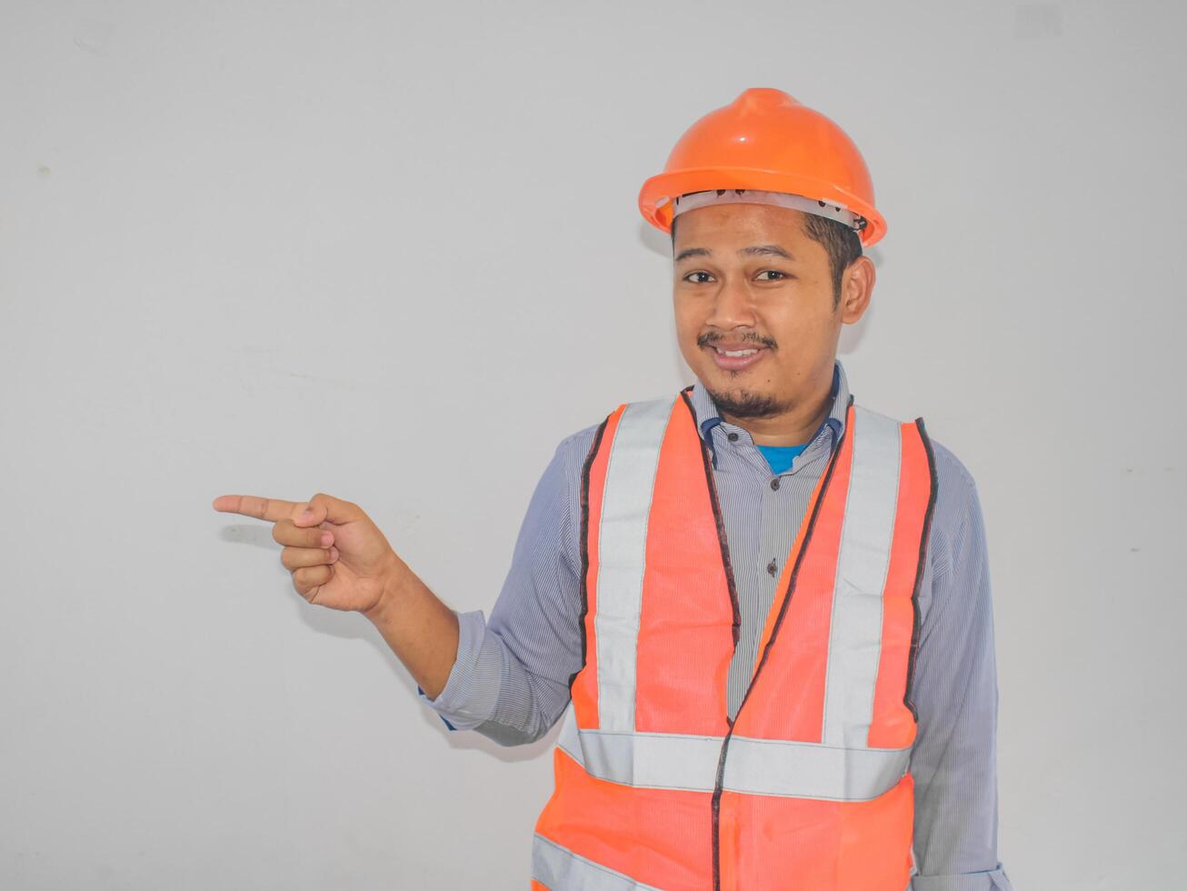 A man wearing construction pointing right gesture choosing someone against white background photo