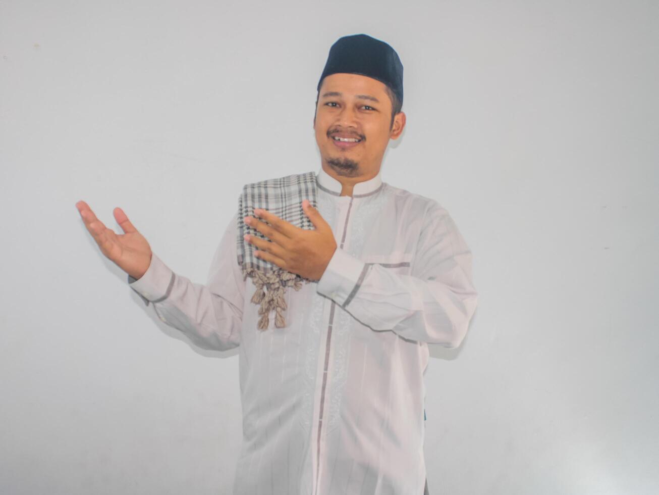 Moslem Asian man smiling and pointing both hands to the side photo
