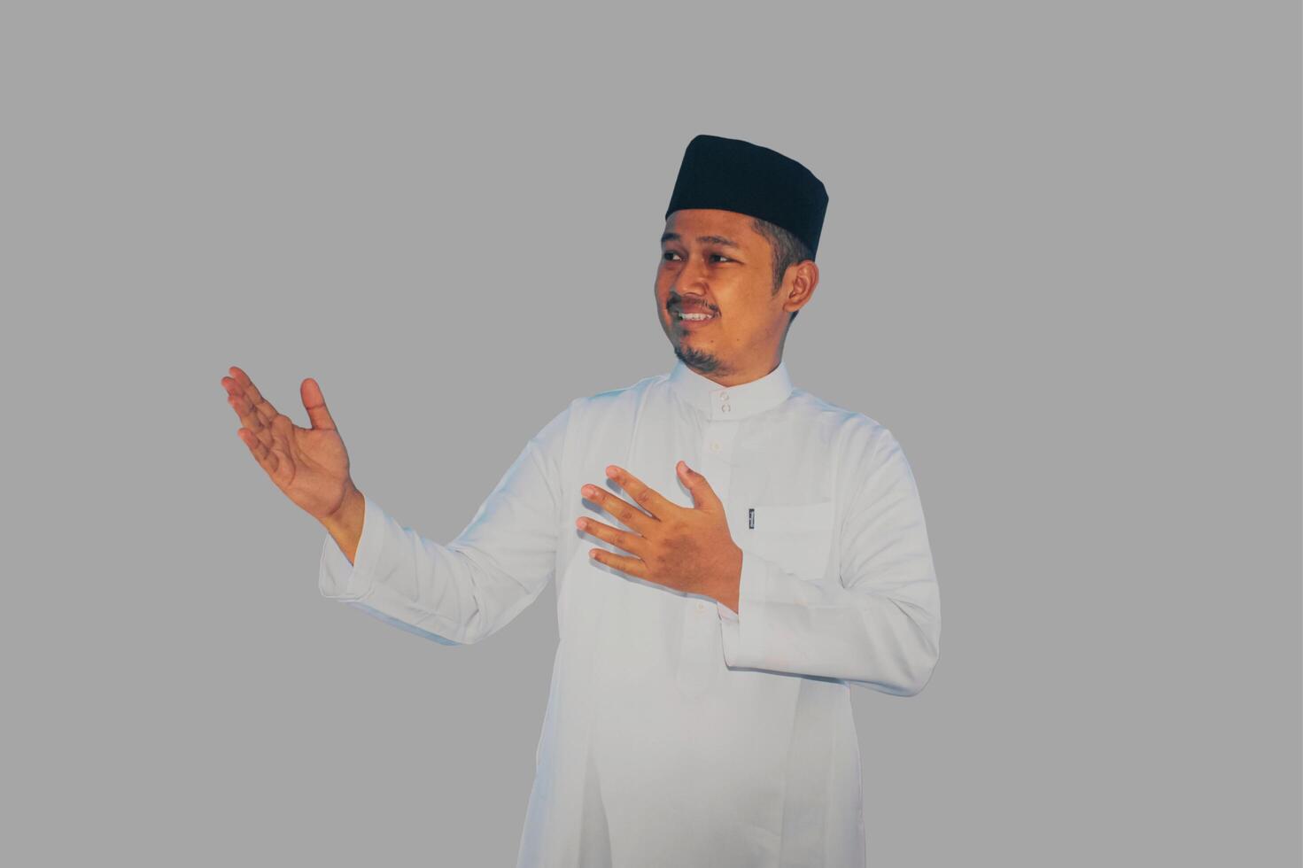 Moslem Asian man smiling at the camera while letting someone to coming inside photo