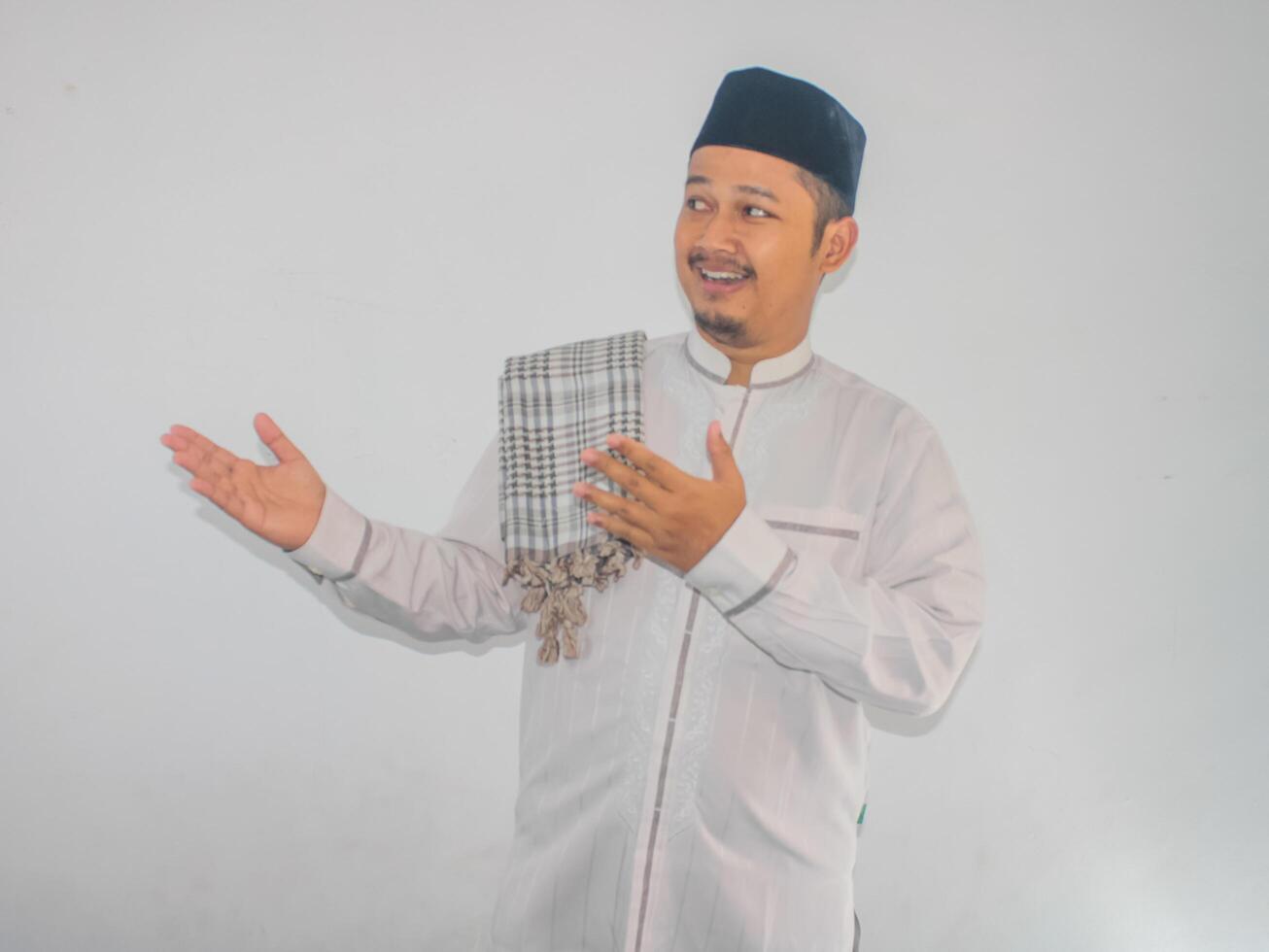 Moslem Asian man smiling and pointing both hands to the side photo
