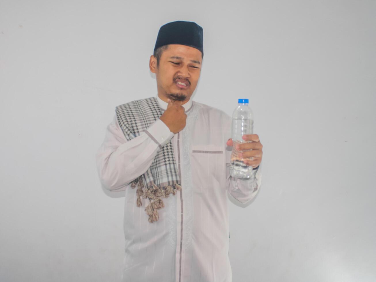 Moslem Asian man showing relieved expression after drink a water photo