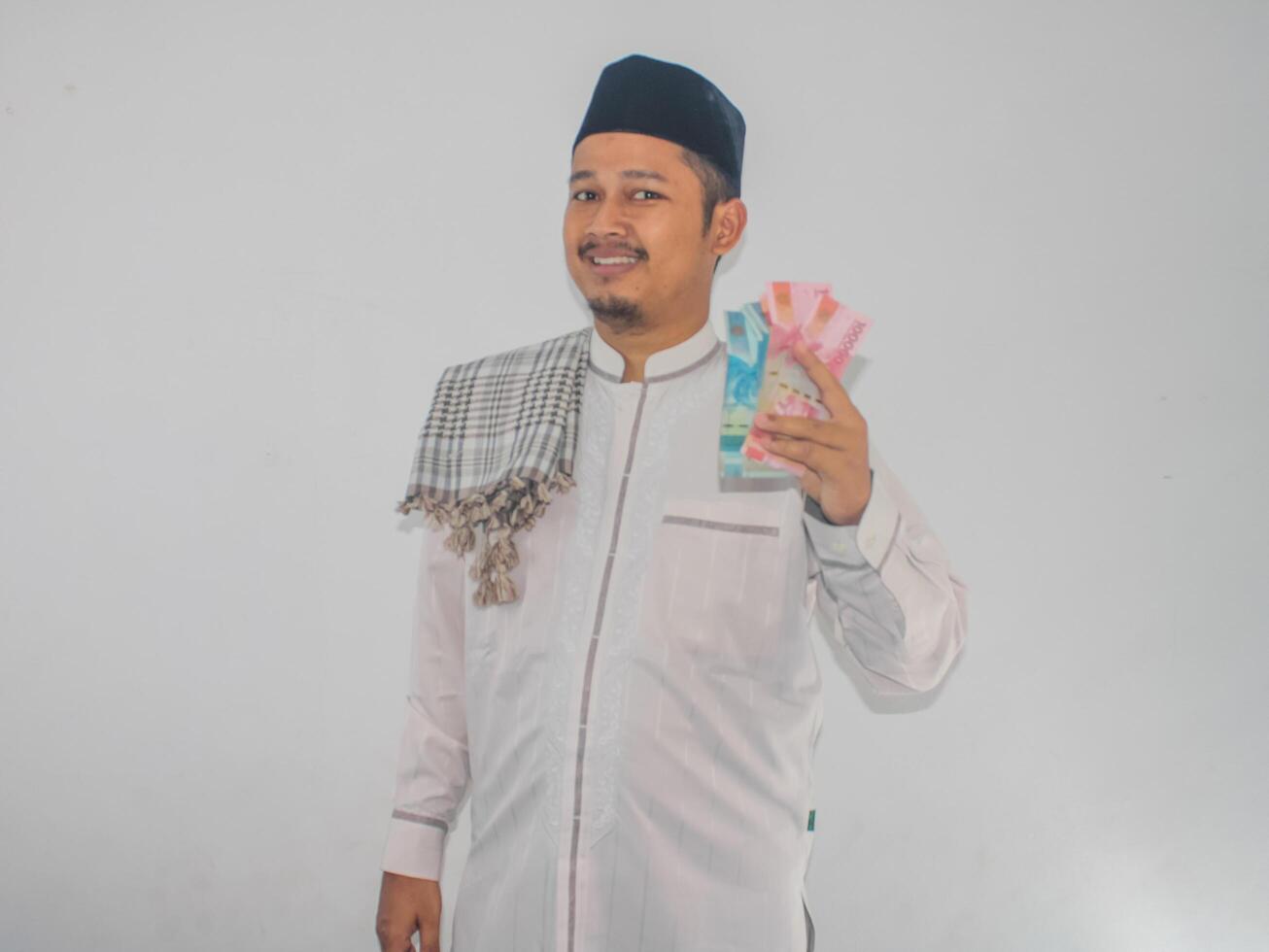 Asian Moslem man smiling happy while showing paper money photo