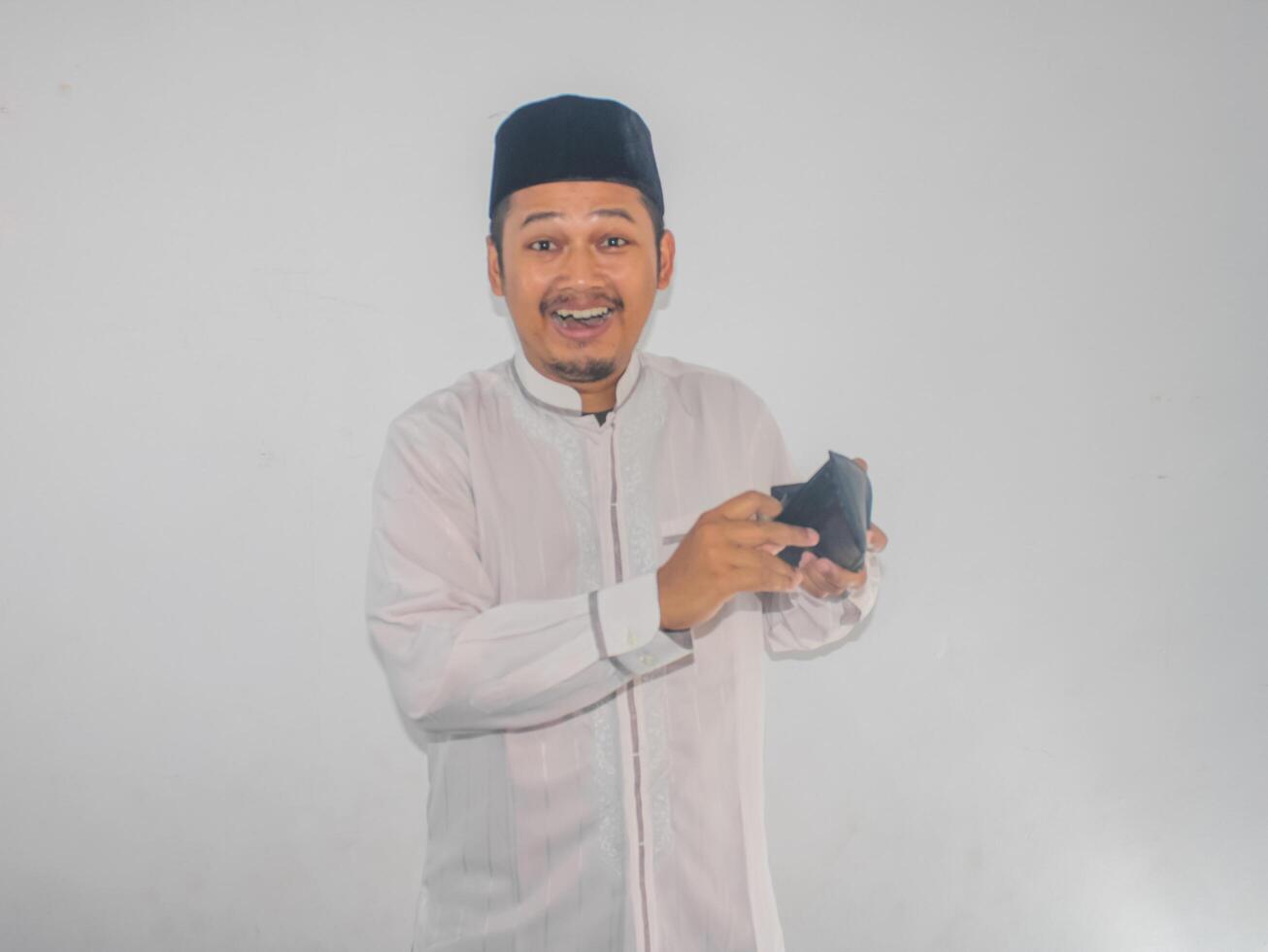 Adult moslem Asian man open his wallet and showing excited expression photo