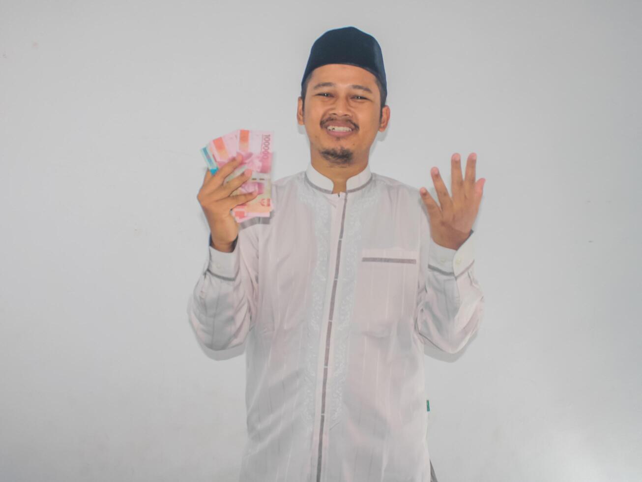 Moslem Asian man showing grateful gesture while holding paper money photo