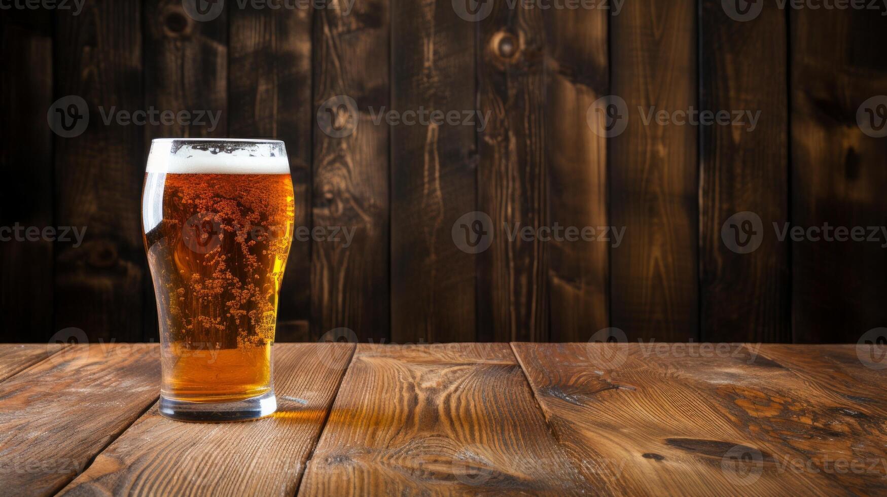 Glass of beer on a wooden table against a dark wooden wall background photo