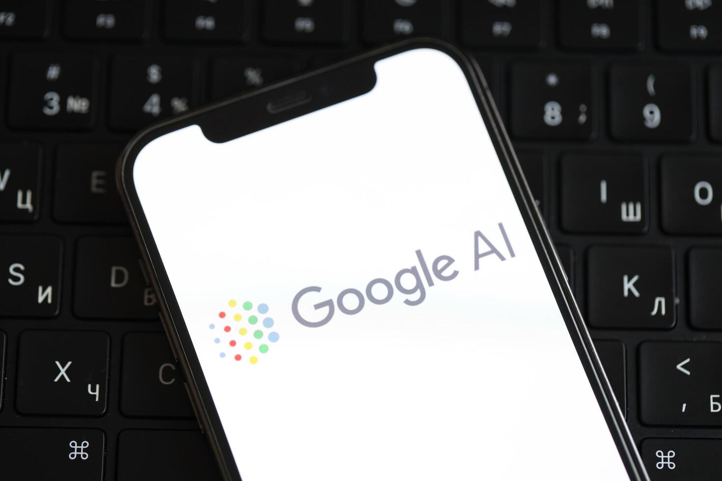 KYIV, UKRAINE - MARCH 17, 2024 Google AI logo on iPhone display screen and MacBook keyboard photo