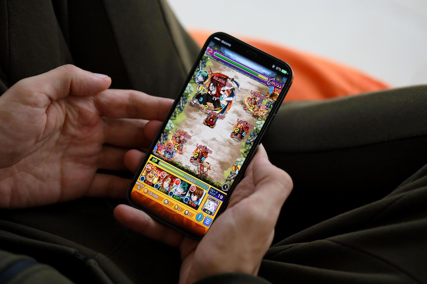 Monster Strike mobile iOS game on iPhone 15 smartphone screen in male hands during mobile gameplay photo