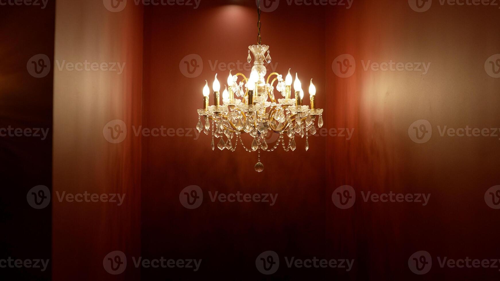 Antique crystal chandelier on a dark background. Beautiful modern chandelier in a red interior. photo