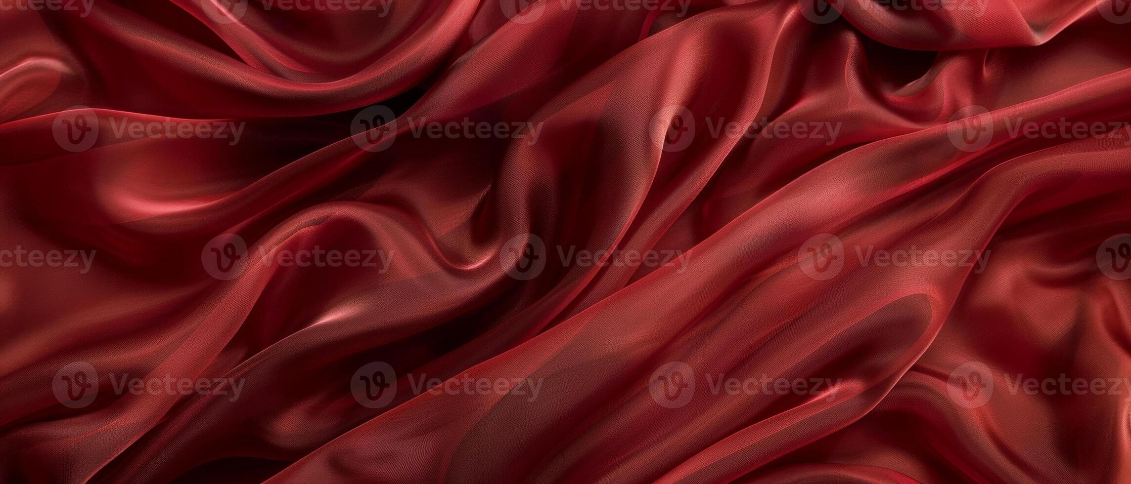 Luxurious burgundy satin fabric flows in soft waves and elegant folds, showcasing the rich texture and warm tones of the material. photo