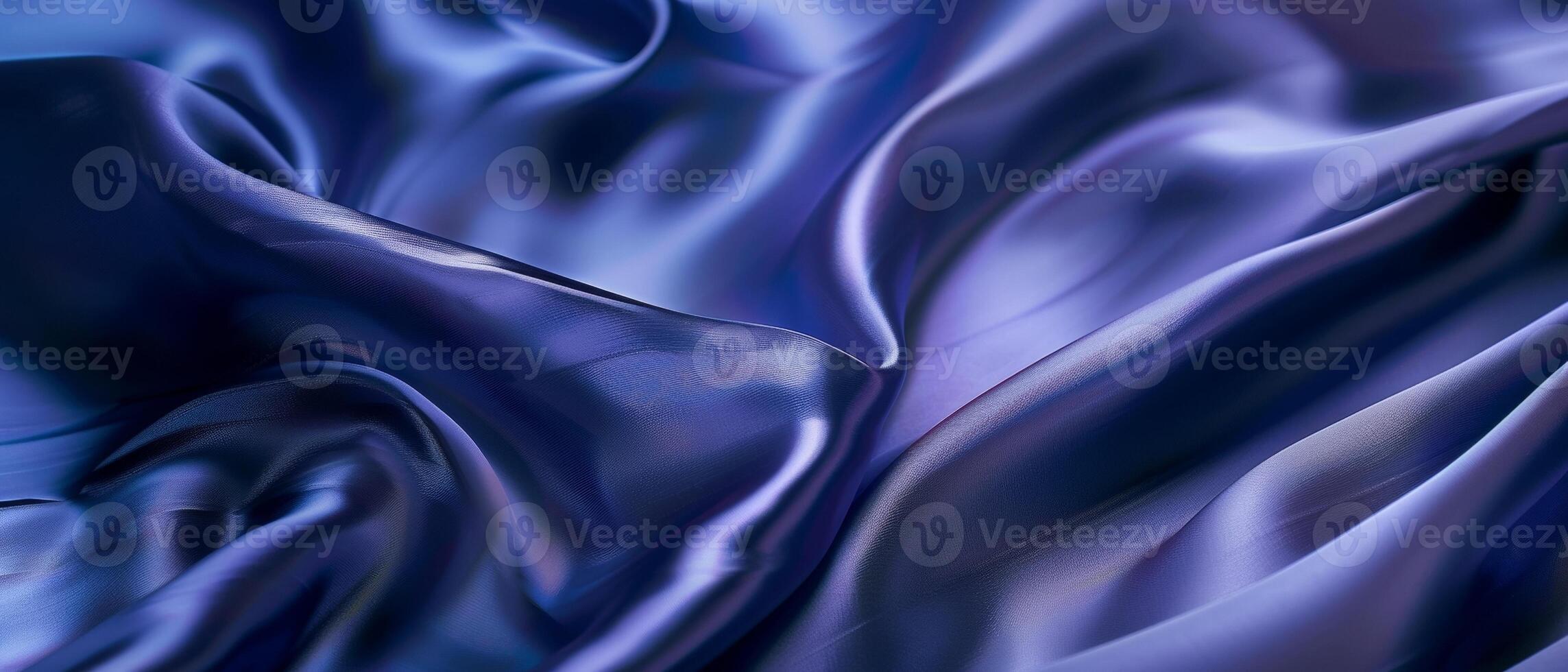 Rippling azure blue satin draped in fluid waves, the light playing across the lustrous folds of the vibrant fabric. photo
