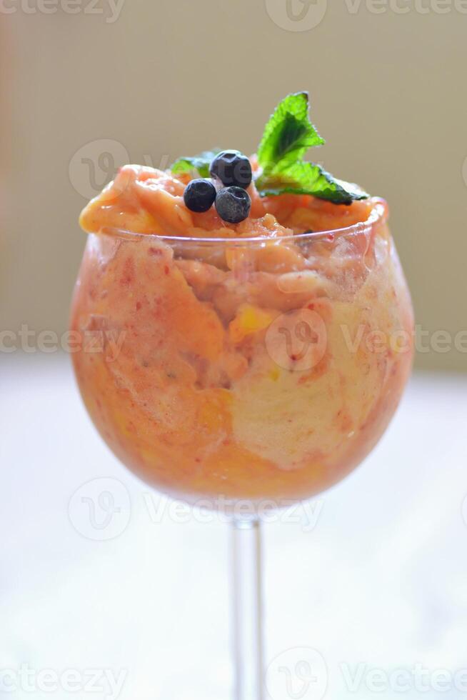 home made ice cream with raspberry, blackberry, mango fruits served in wine glasses. photo