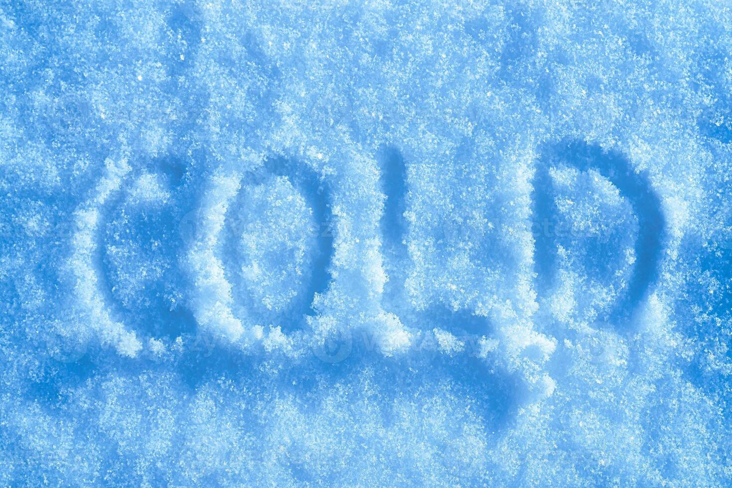 The word cold written on the snow. Winter and cold weather. photo