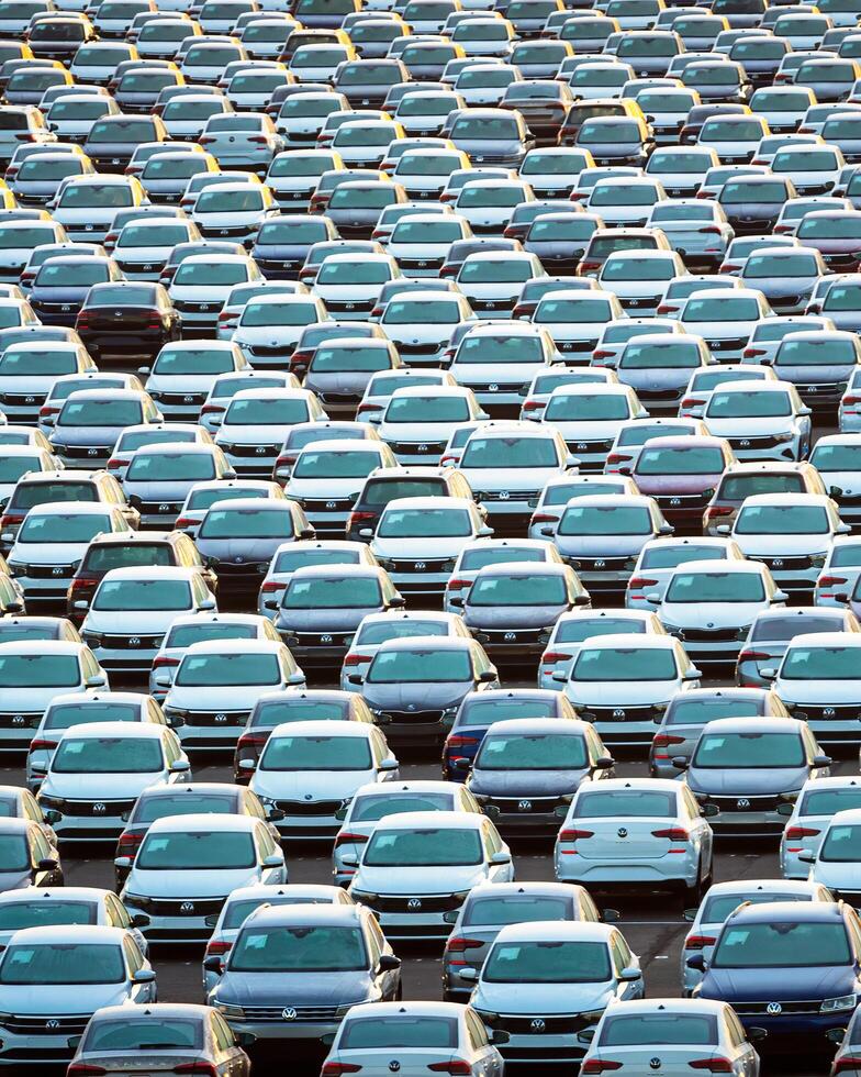 Volkswagen Group Rus, Russia, Kaluga - MAY 25, 2020 Rows of a new cars parked in a distribution center on a sunny morning in the autumn. photo
