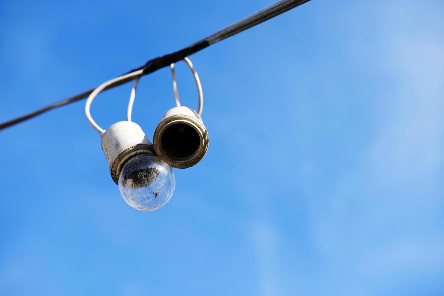 Equipped and electrical with light bulbs is hanging in the wind and sunlight on blue sky photo