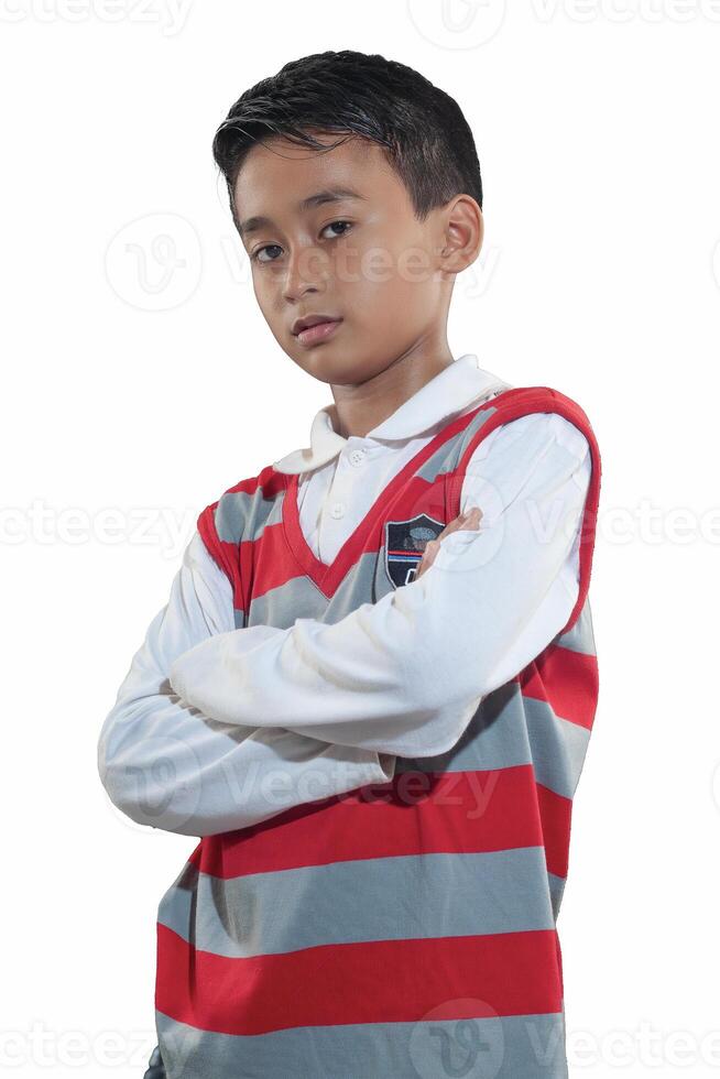 an indonesian 10 years old boy wearing red stripe sweater with crossed arm pose photo