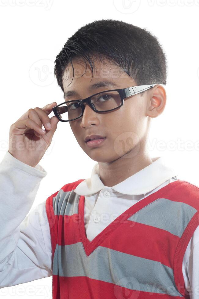 an indonesian 10 years old boy wearing red stripe sweater with holding glasses photo