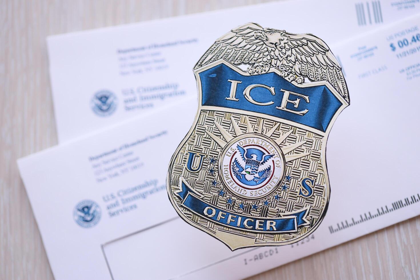 KYIV, UKRAINE - MARCH 9, 2024 US ICE Officer badge on USCIS mail envelope photo