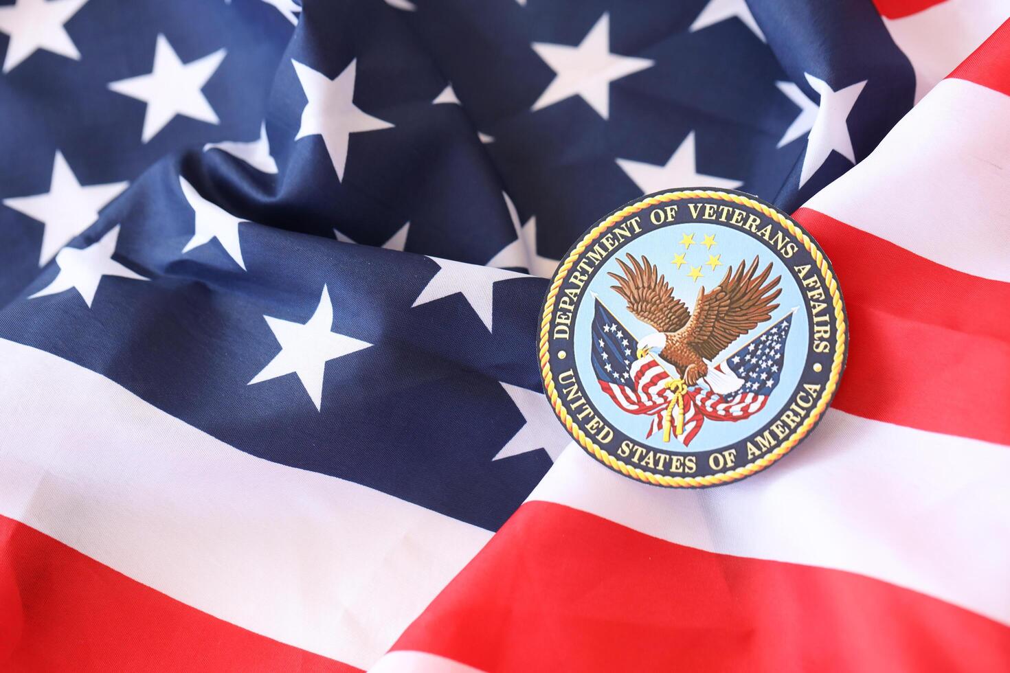 KYIV, UKRAINE - MARCH 9, 2024 US Department of Veteran Affairs seal on United States of America flag photo
