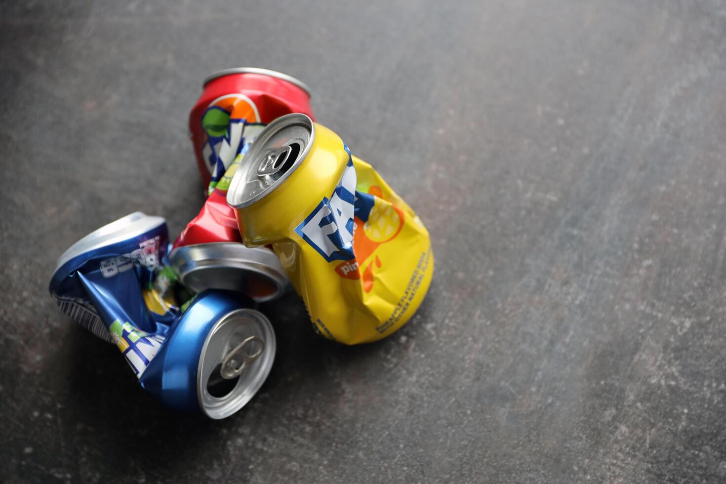 KYIV, UKRAINE - 4 MAY, 2023 Fanta soft drink brand crumpled tin cans with various flavours photo