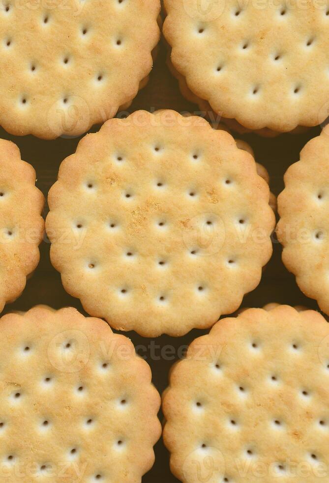 Detailed picture of round sandwich cookies with coconut filling. Background image of a close-up of several treats for tea photo