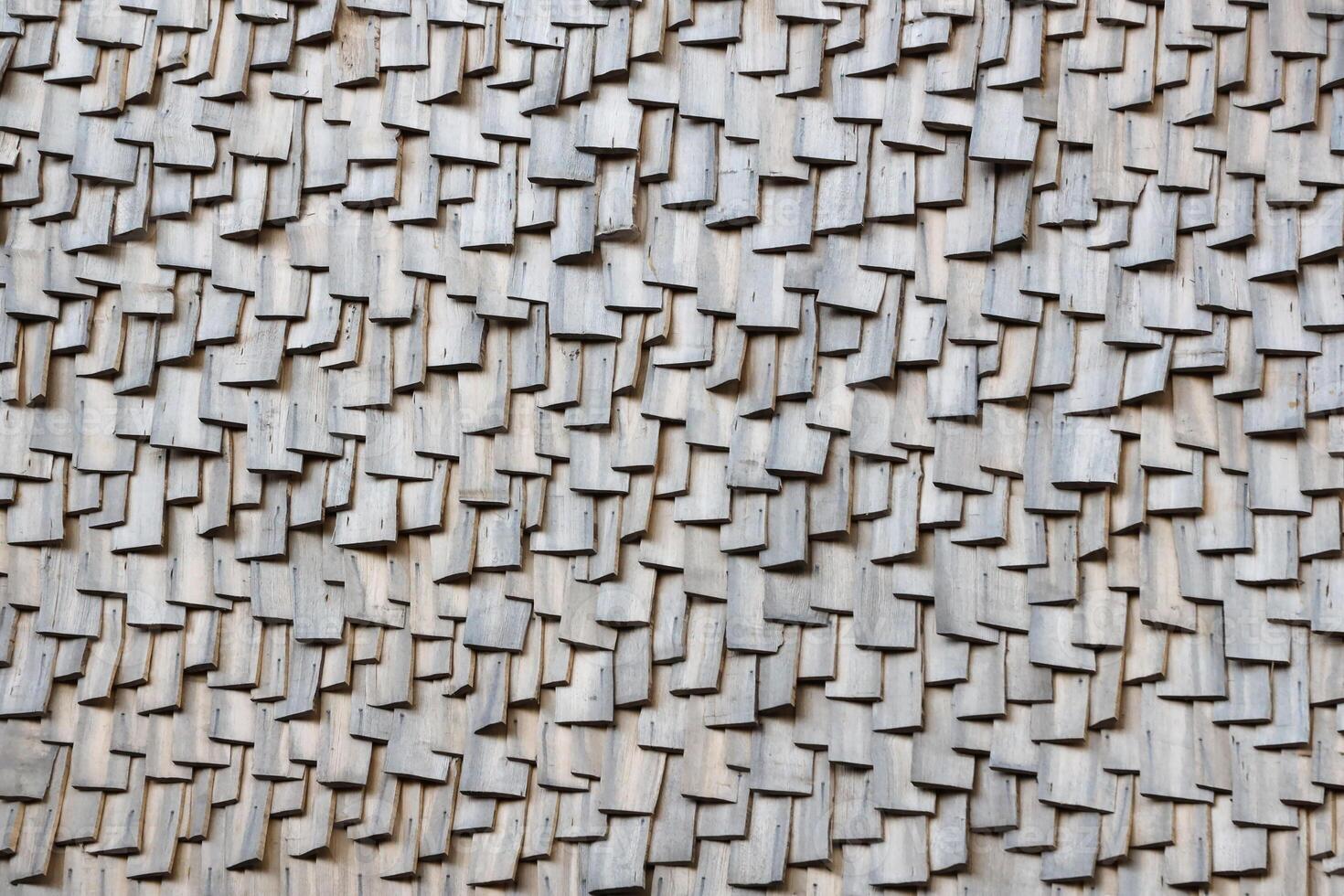 Gray wooden roof tiles background texture. A close up of old gray roof covered with wooden tiles photo