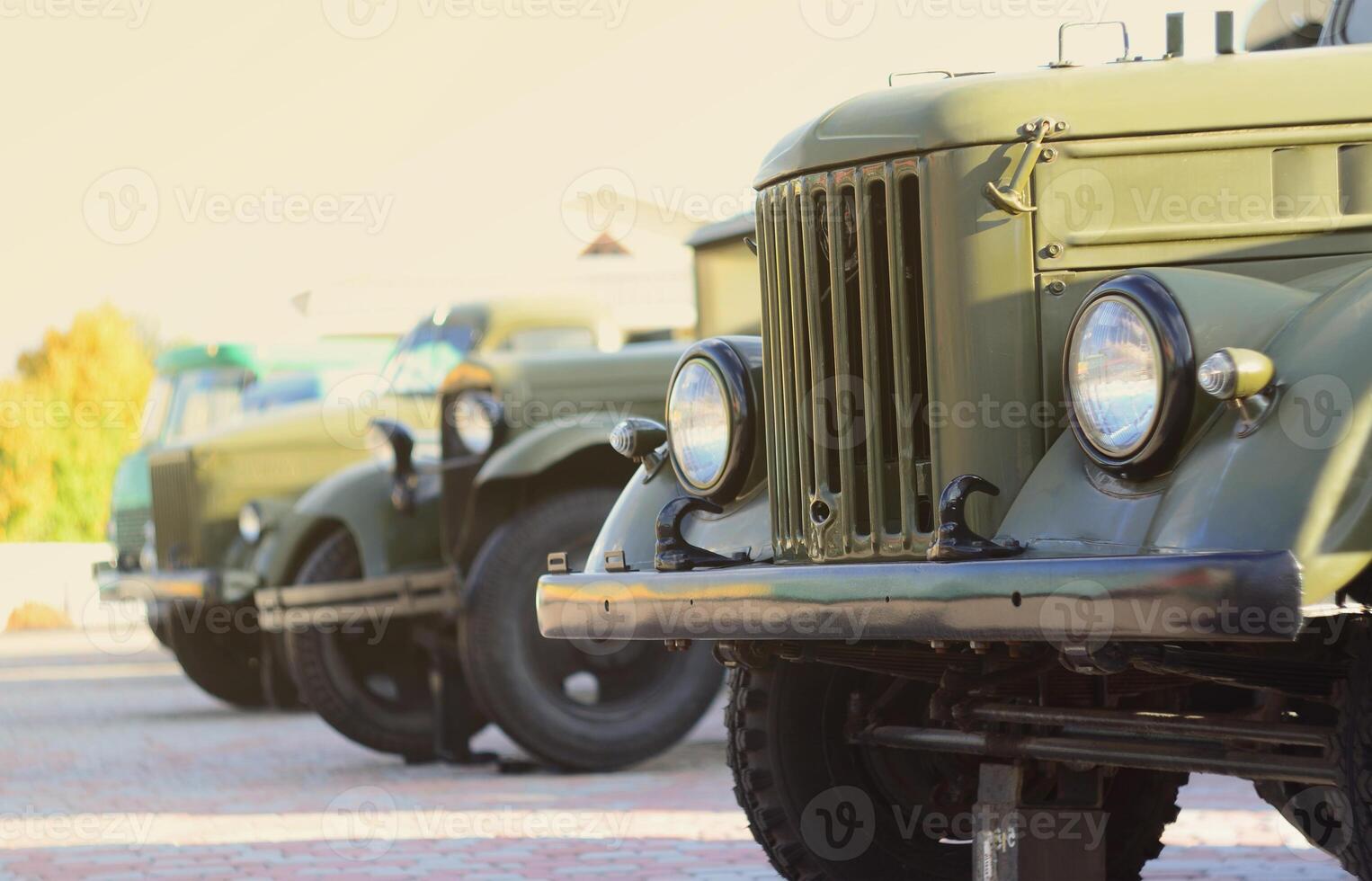 Photo of the cabins of three military off-road vehicles from the times of the Soviet Union. Side view of military cars from the front wheel