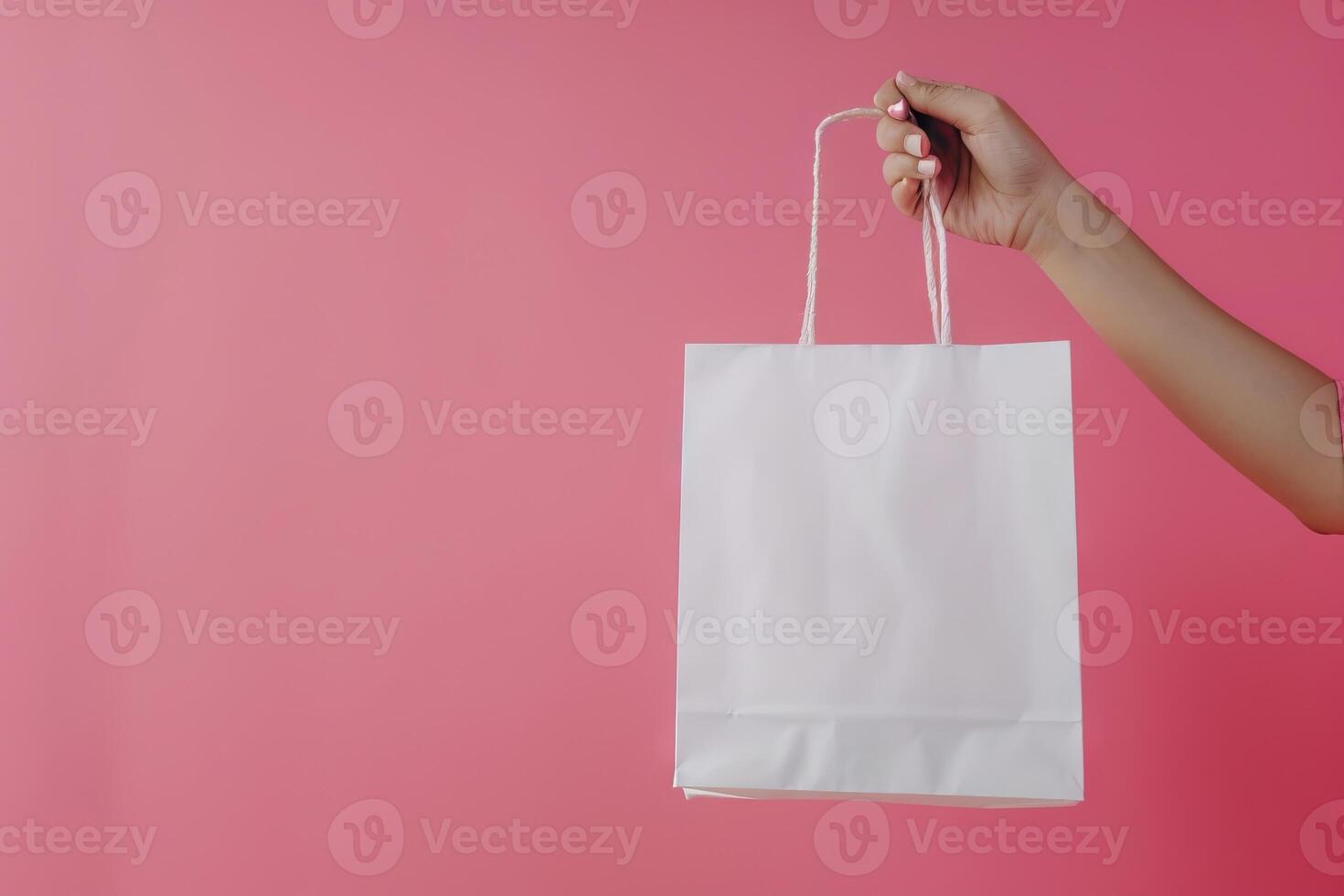 AI generated Female hand holding white shopping bag on pink background. Discount sale concept. photo