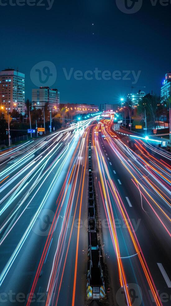 Streaks of moving car lights against the backdrop of city lights at night photo